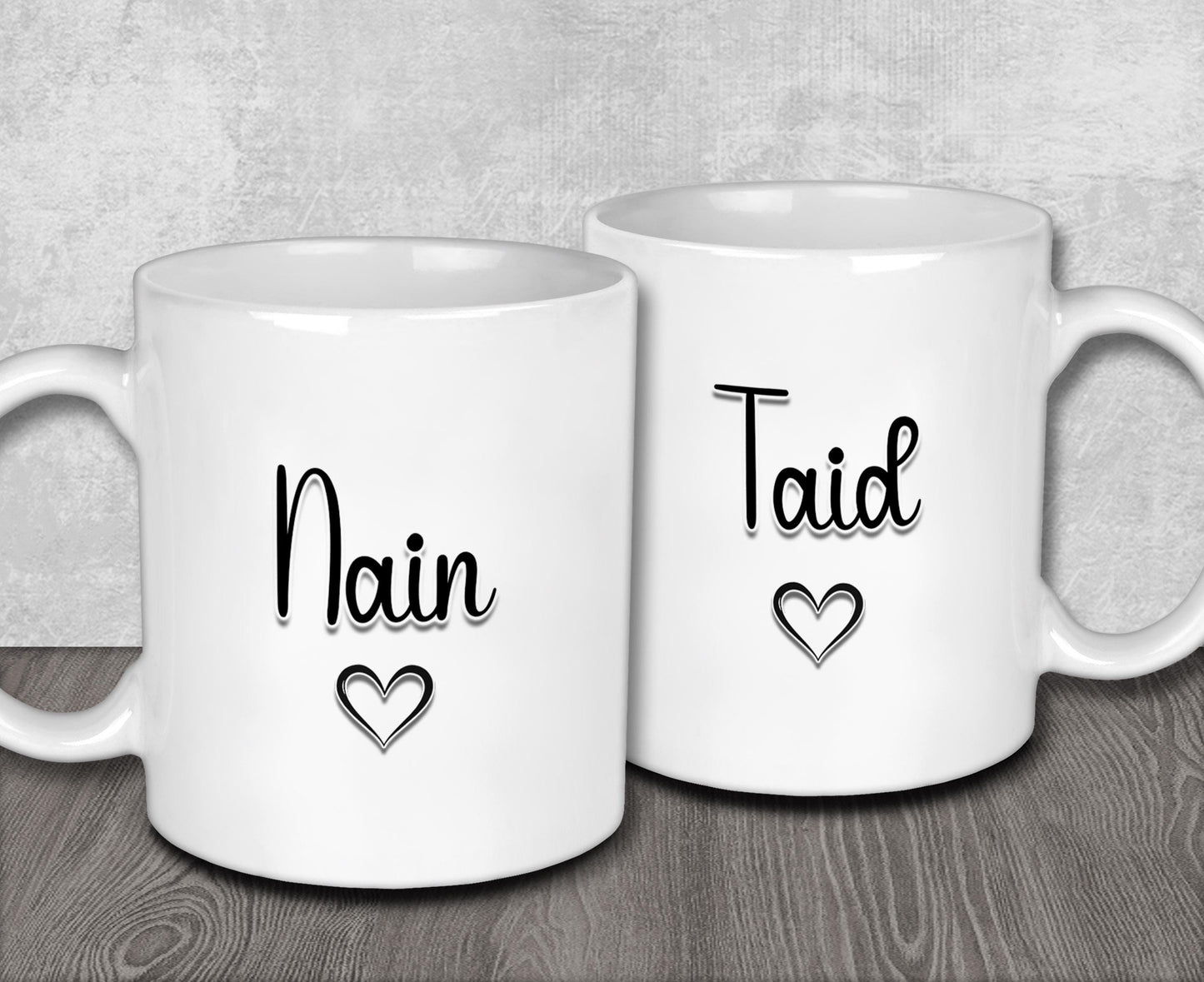 two white coffee mugs with black lettering on them