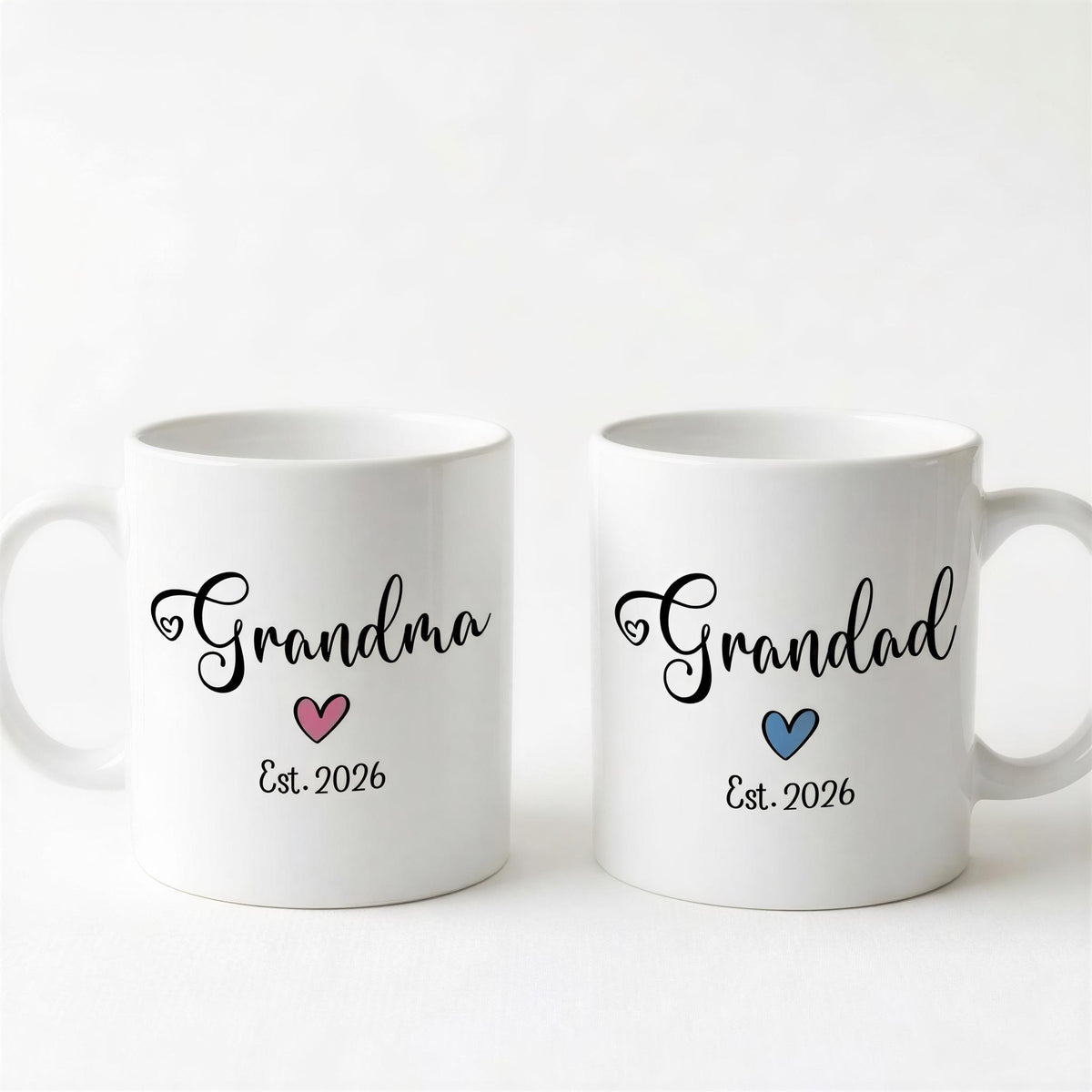 Two white ceramic mugs with the text "Grandma" and "Grandpa" printed on them, along with the year "Est. 2026" below the text.