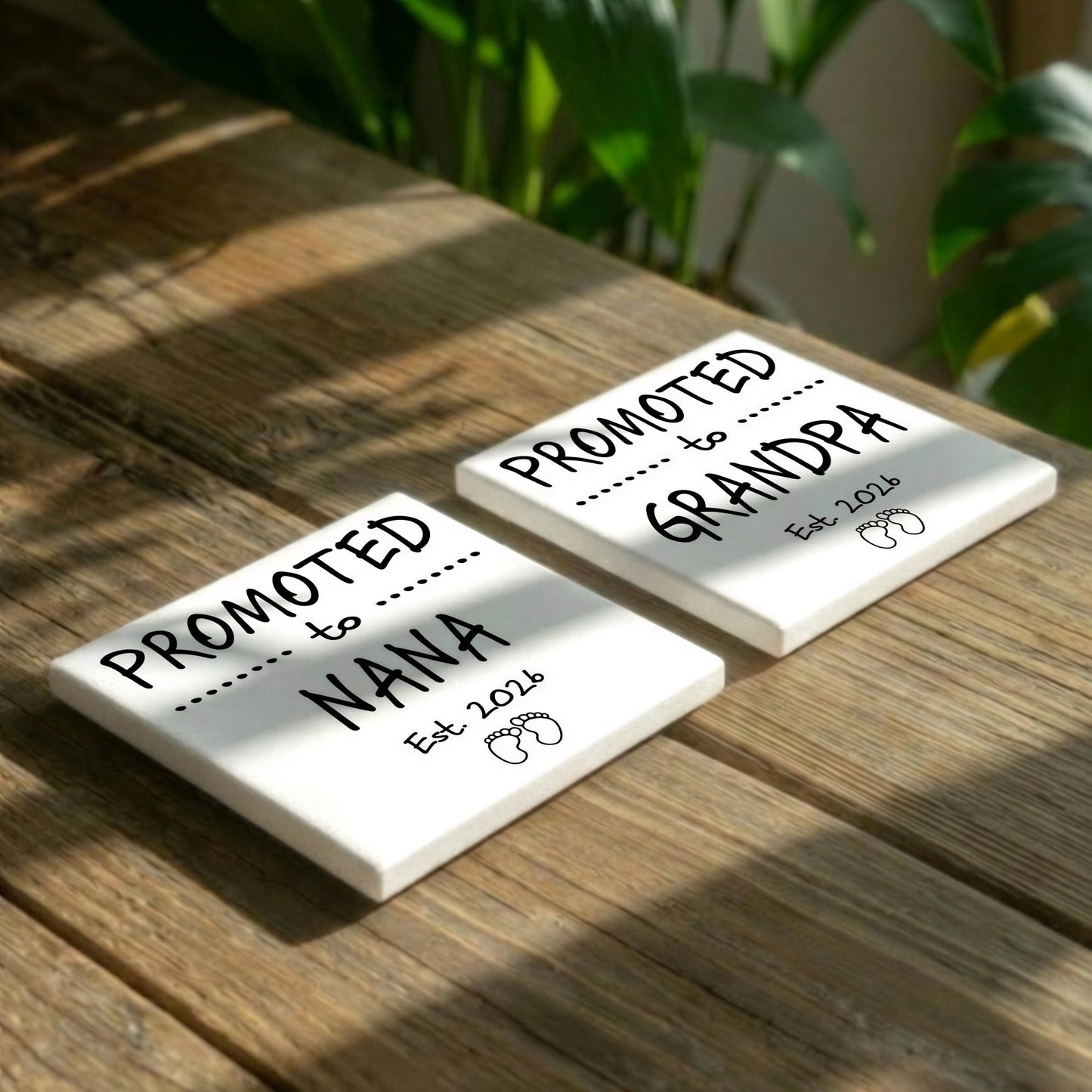 Two white coasters with black text and illustrations, placed on a wooden surface.