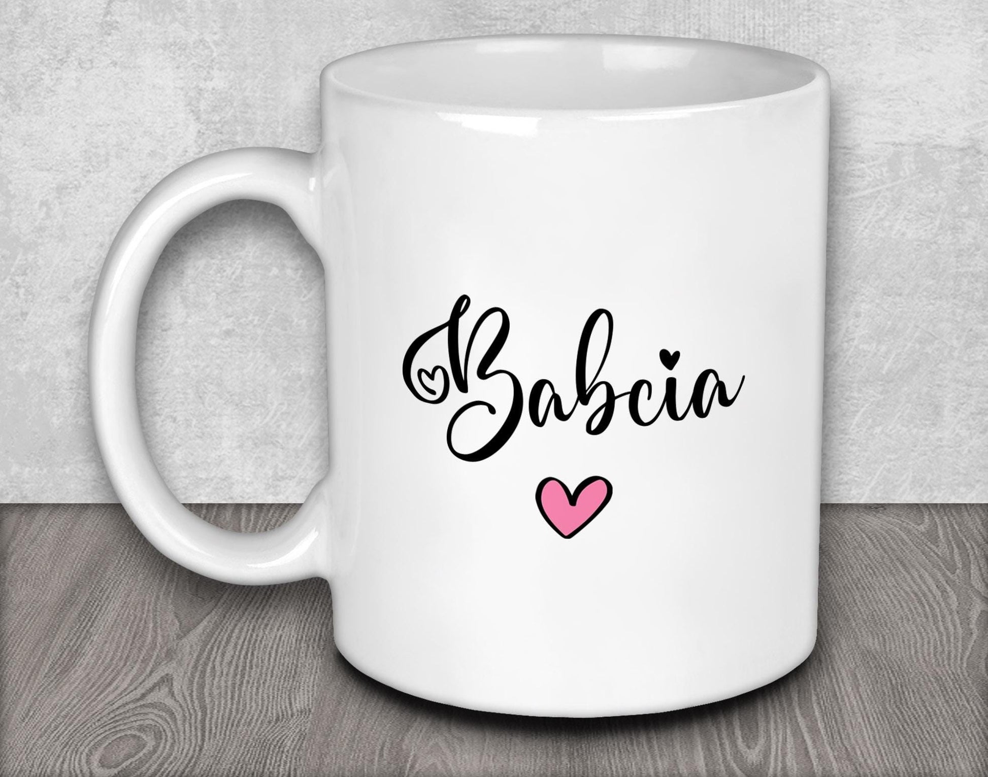 a white coffee mug with a pink heart on it