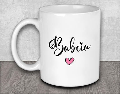 a white coffee mug with a pink heart on it