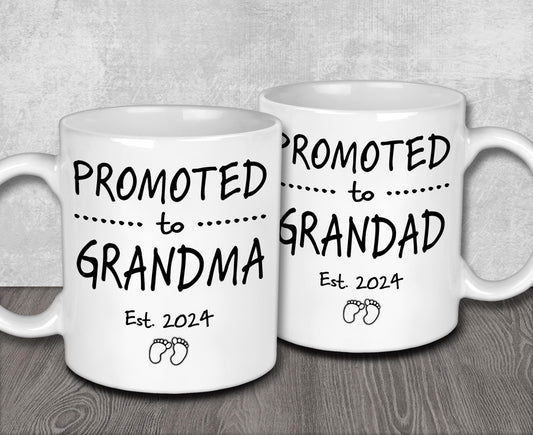 two white coffee mugs sitting on top of a wooden table