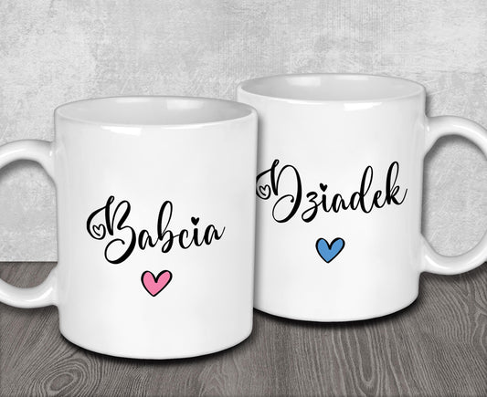two white coffee mugs sitting on top of a wooden table