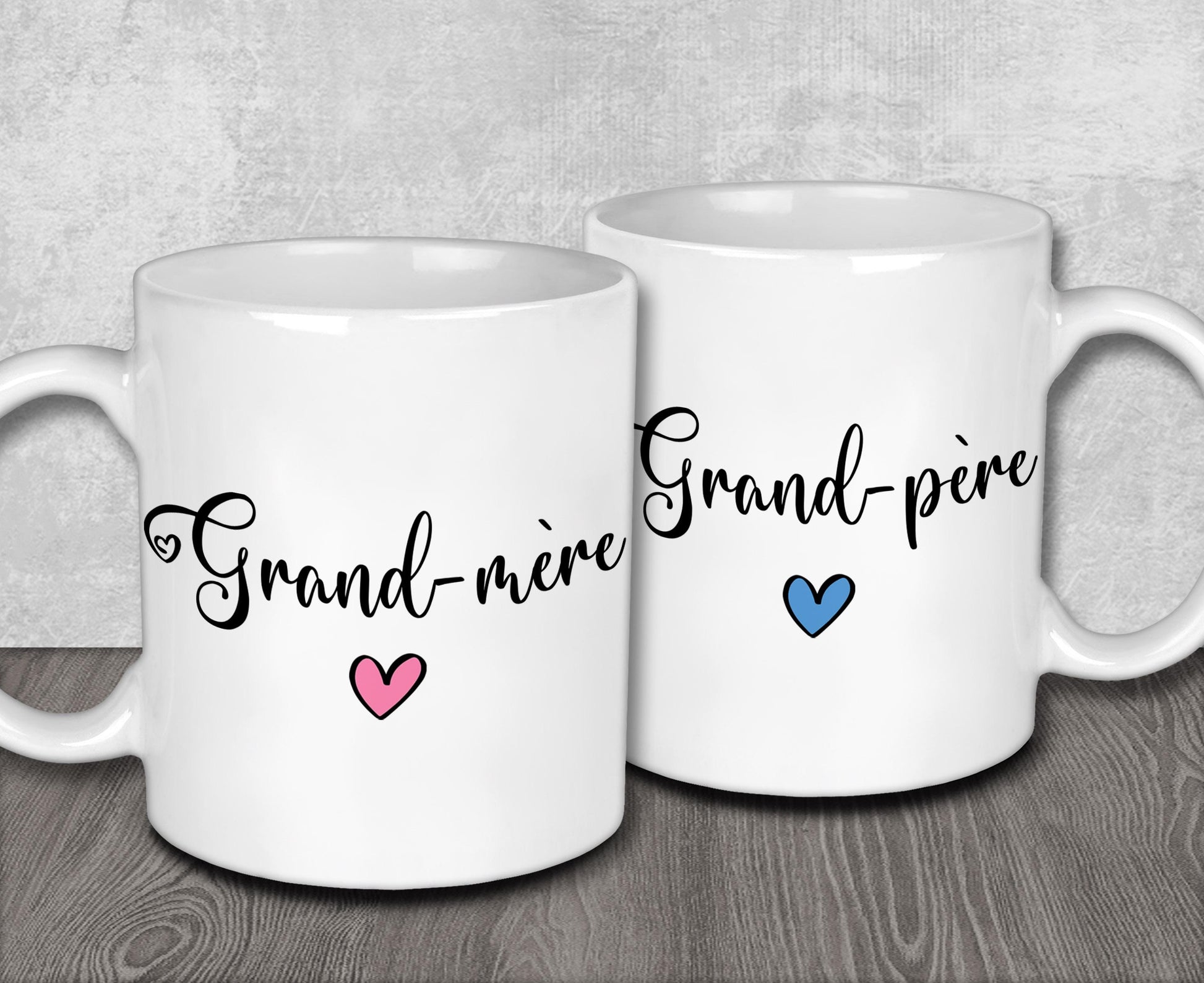 two white coffee mugs sitting on top of a wooden table