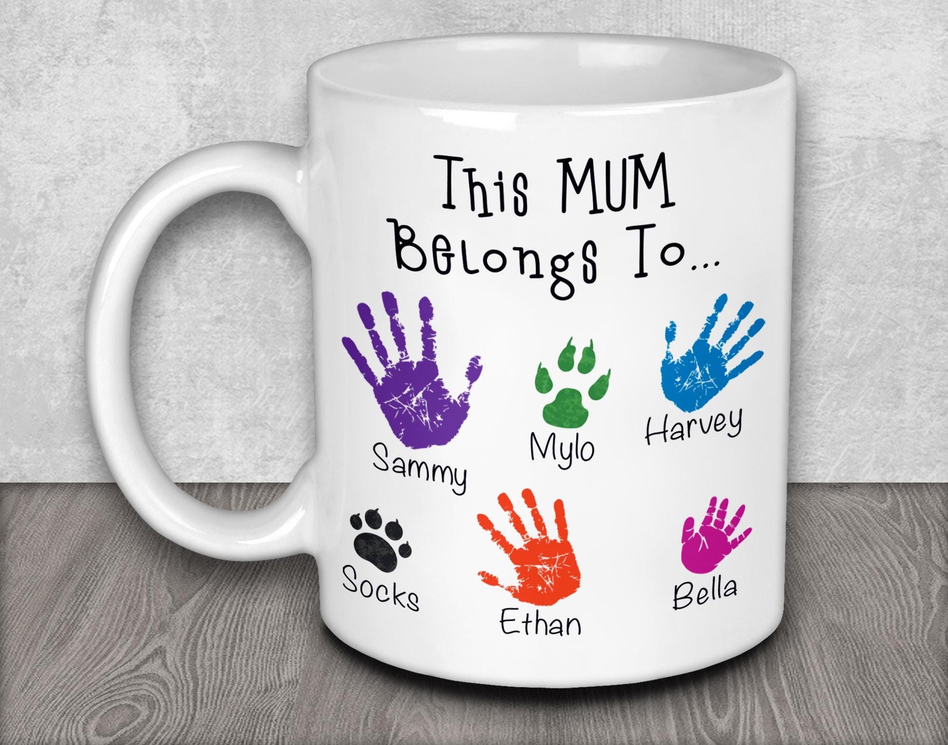 a white coffee mug with colorful hand prints on it