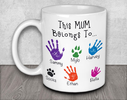 a white coffee mug with colorful hand prints on it