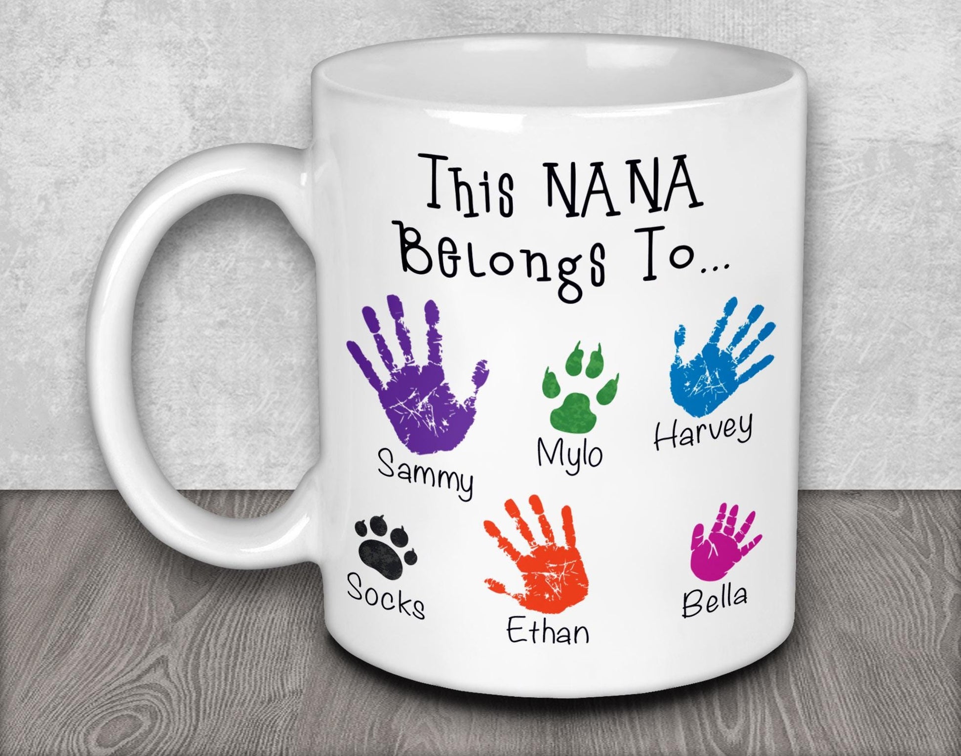 a white coffee mug with colorful hand prints on it