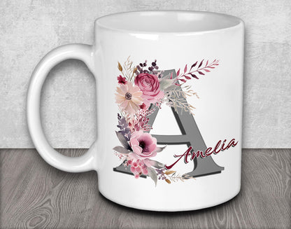 a white coffee mug with flowers and the letter a