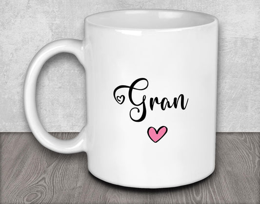 a white coffee mug with a pink heart on it