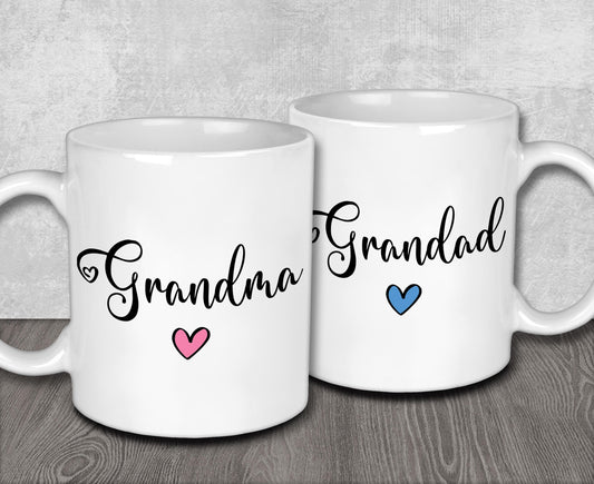 a couple of white coffee mugs sitting on top of a wooden table