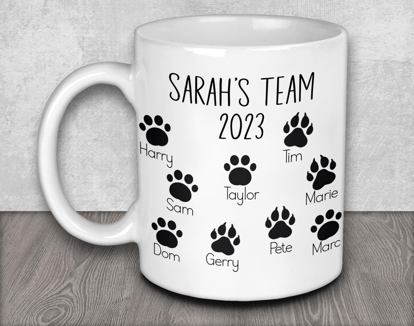 a white coffee mug with a dog&#39;s name and paw prints