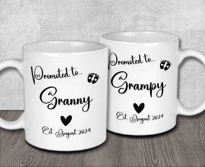 a couple of white coffee mugs sitting on top of a wooden table