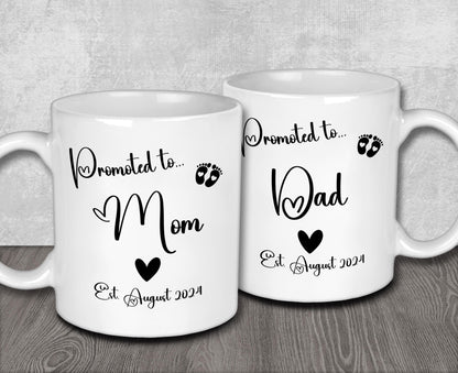 two white coffee mugs sitting on top of a wooden table