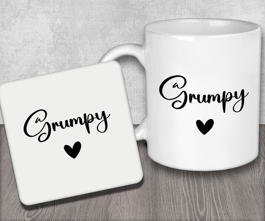 a couple of white coffee mugs sitting on top of a wooden table
