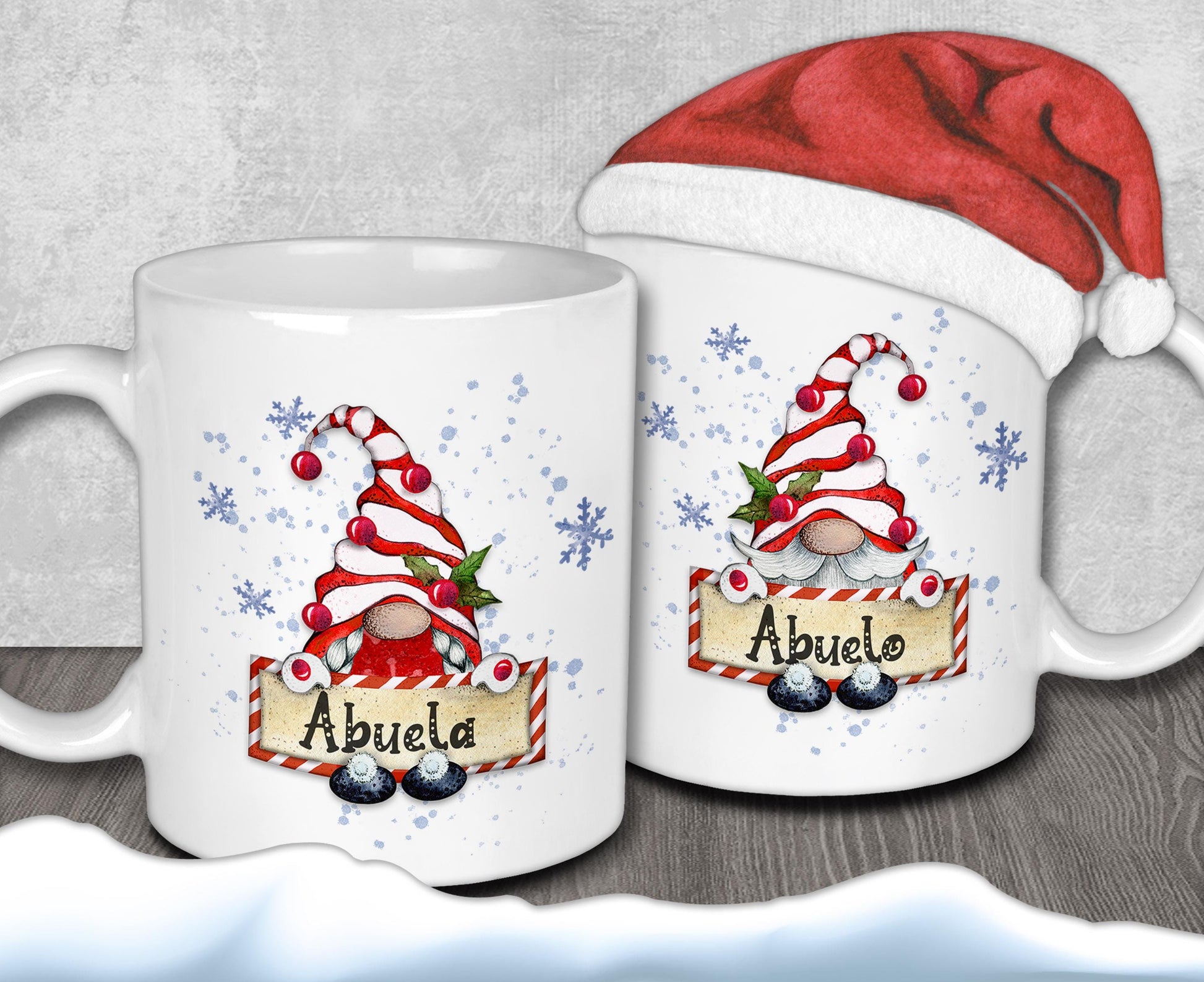 two white mugs with Christmas-themed designs, including gnomes and snowflakes. One mug has the name &quot;Abuela&quot; written on it, while the other mug has the name &quot;Abuelo&quot; written on it. Both mugs are decorated with festive elements, such as snowflakes and red and white striped gnomes.