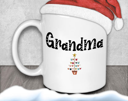 A white mug with the text &quot;Grandma&quot; and a Christmas tree graphic printed on it, along with a Santa hat.