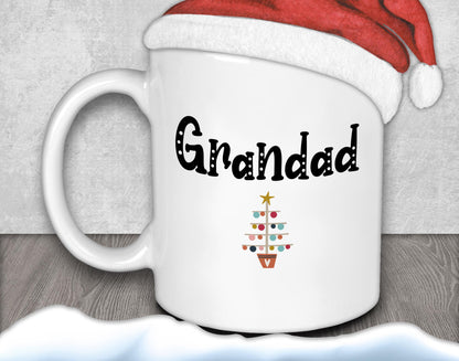 A white mug with the word "Grandad" written on it, along with a small Christmas tree design.