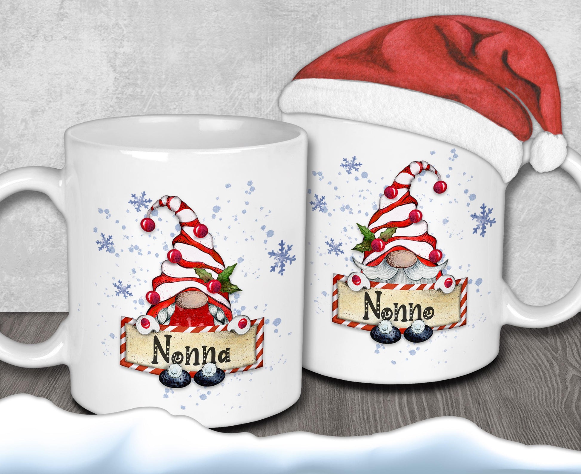 two white mugs with Christmas-themed designs, including gnomes and snowflakes. One mug has a red Santa hat on top, and the other mug has the name "Nonna" written on it.