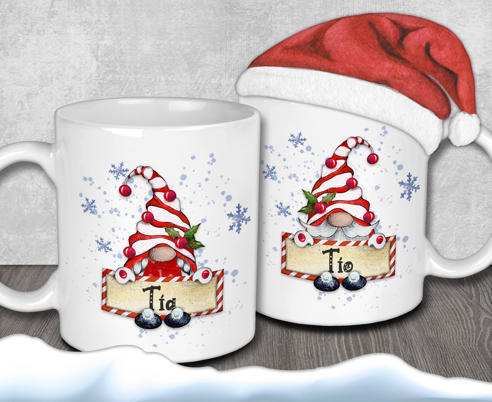 two white mugs with Christmas-themed designs, including gnomes and snowflakes. One mug has a Santa hat on top, and the other mug has the name "Tio" written on it.