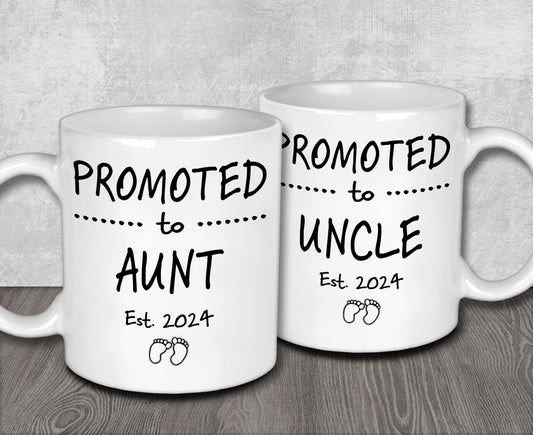 two white coffee mugs sitting on top of a wooden table