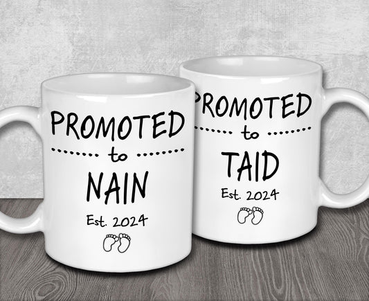 two white coffee mugs sitting on top of a wooden table