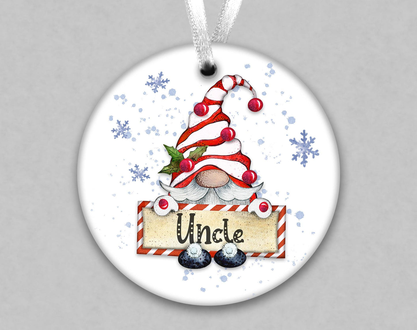 A white ornament with a gnome-like figure wearing a red and white striped hat and holding a sign that says &quot;Uncle&quot;.