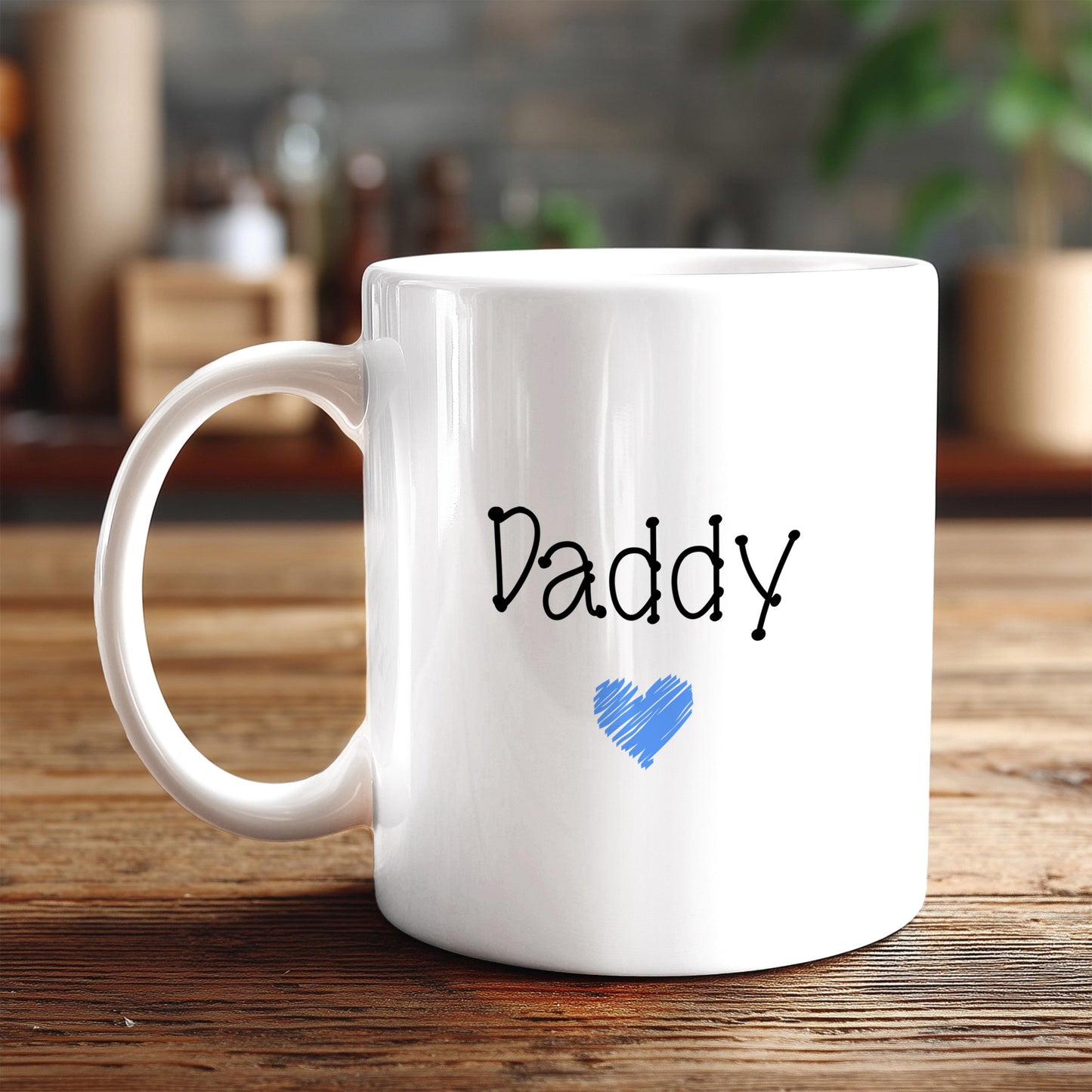 A white ceramic mug with the word "Daddy" printed on it, along with a blue heart symbol, sits on a wooden surface.