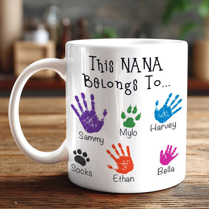 A white mug with a personalized message and handprint designs on it.