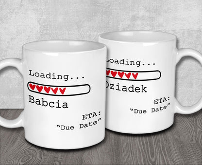 Two white ceramic mugs with a humorous loading bar graphic and text, placed on a wooden surface.