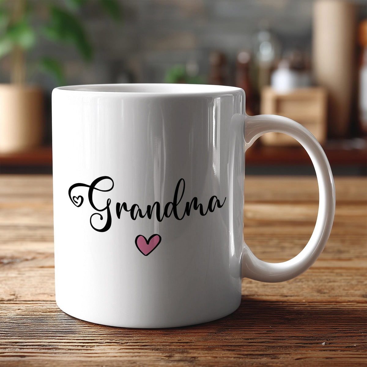 A white ceramic mug with the text "Grandma" and a heart symbol printed on it, placed on a wooden surface.