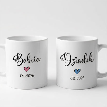 Two white ceramic mugs with black text and heart designs.