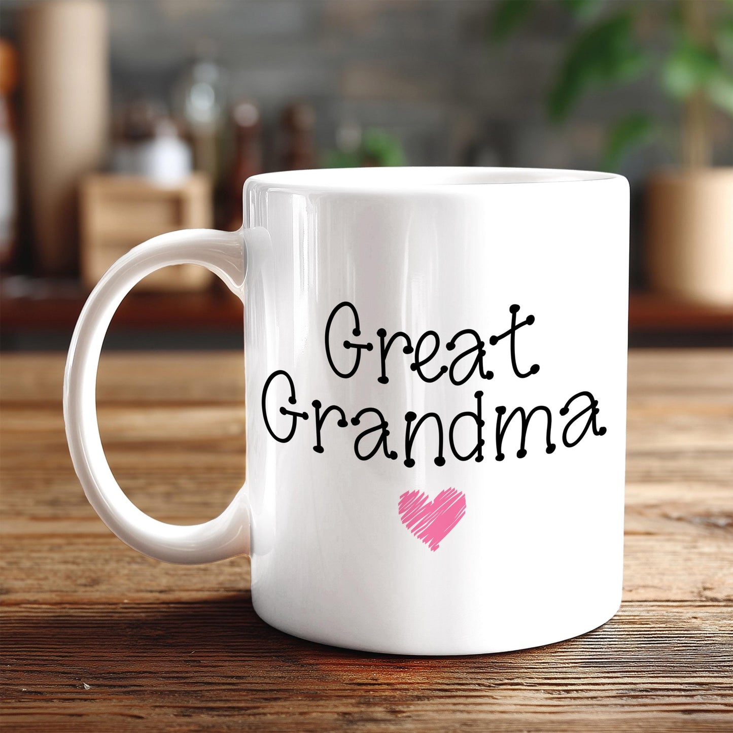 A white ceramic mug with the text "Great Grandma" and a pink heart symbol printed on it, placed on a wooden surface.