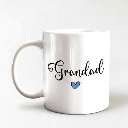 A white ceramic mug with the text "Grandad" and a blue heart symbol printed on it.