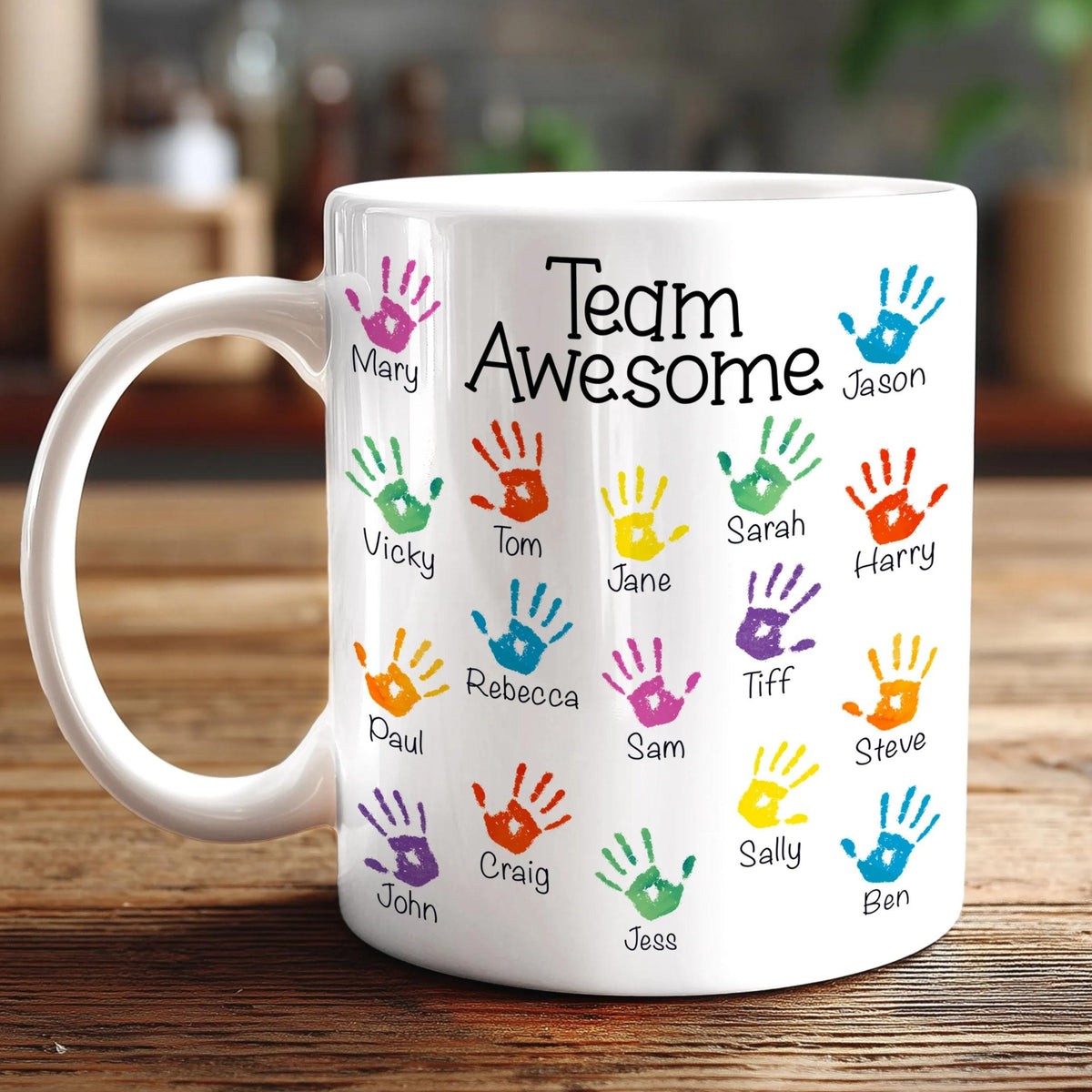 A white mug with colorful handprints on it, each containing a name.