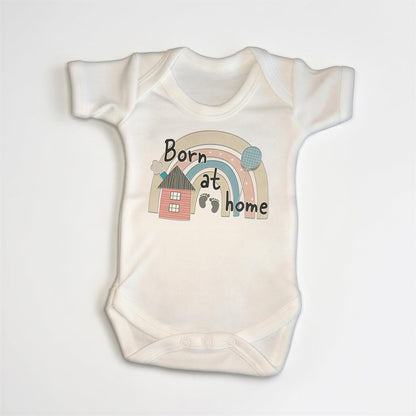 A white baby onesie with a graphic design on it.