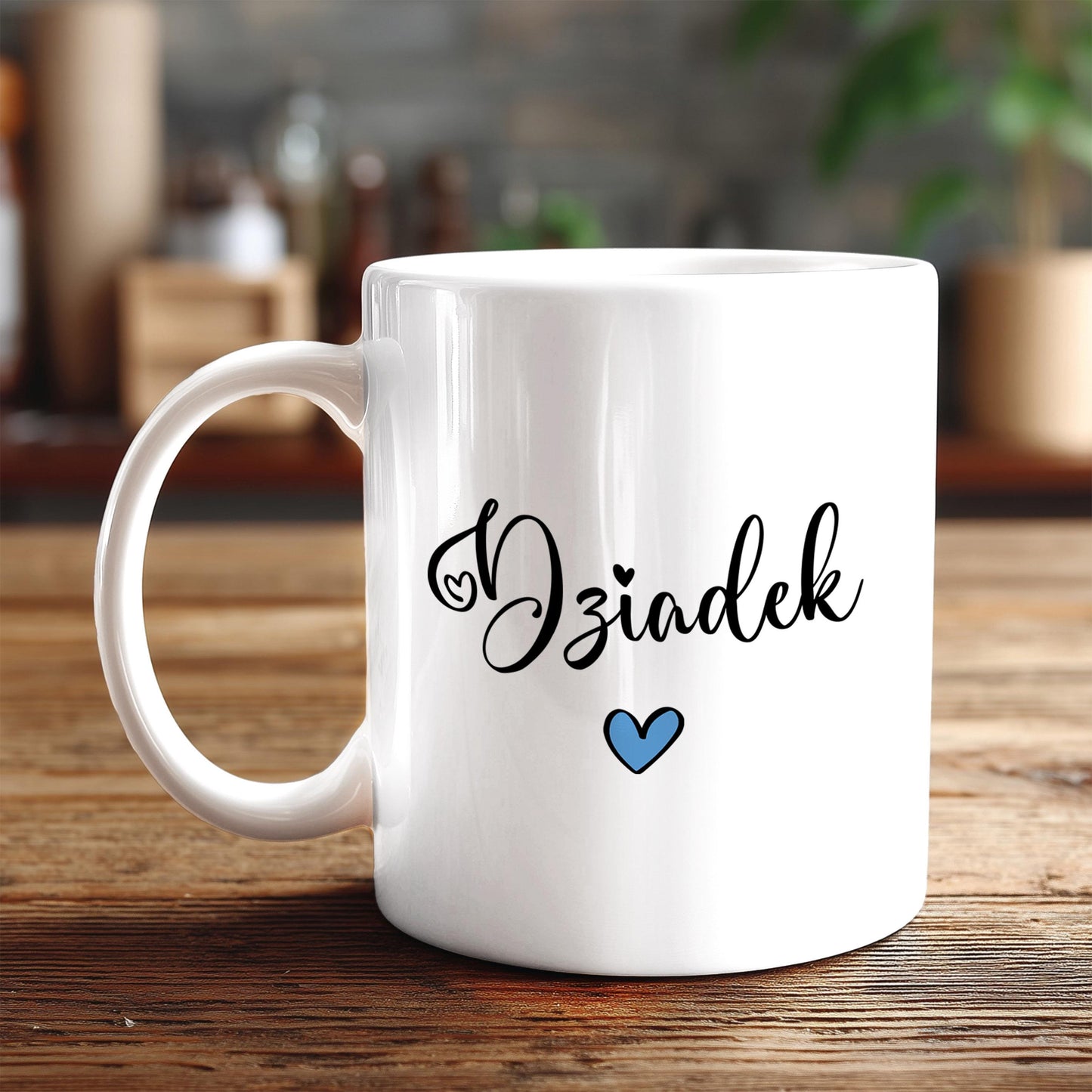 A white ceramic mug with the word "Oziaek" written on it in a cursive font, along with a small blue heart symbol.