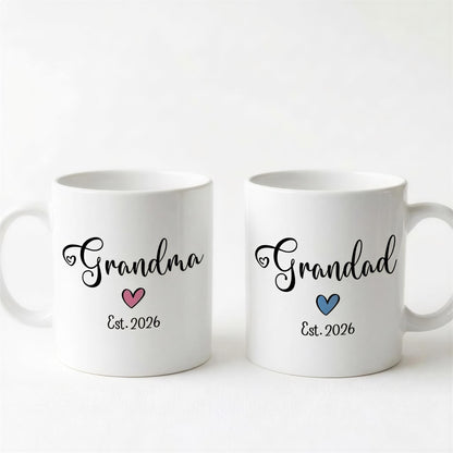 Two white ceramic mugs with the text "Grandma" and "Grandpa" printed on them, along with the year "Est. 2026" below the text.