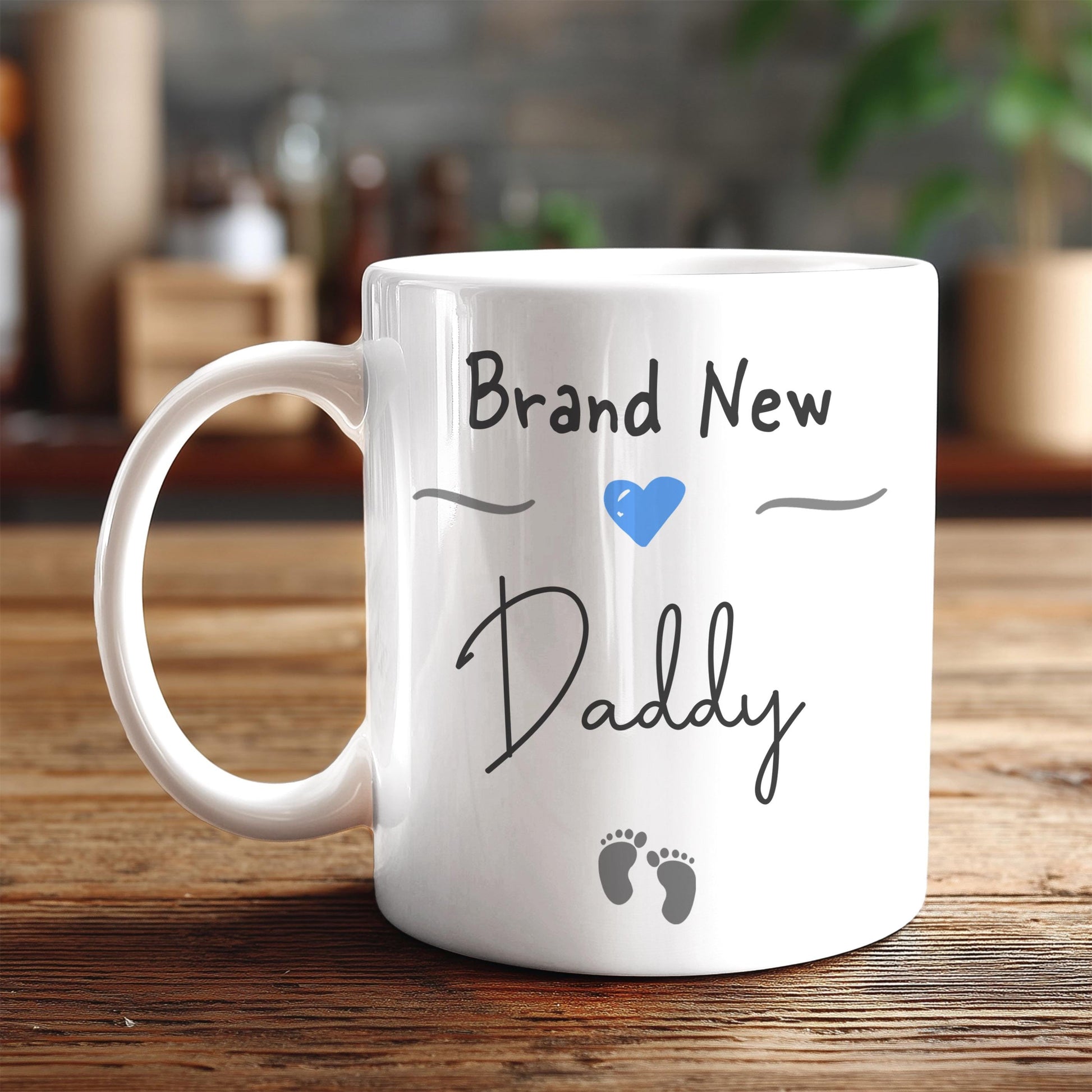 A white ceramic mug with the text "Brand New Daddy" printed on it, along with a blue heart symbol and baby footprints.