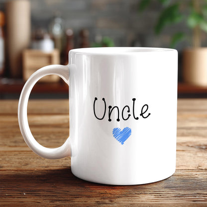 A white ceramic mug with the word "Uncle" written on it, along with a blue heart symbol, sits on a wooden surface.