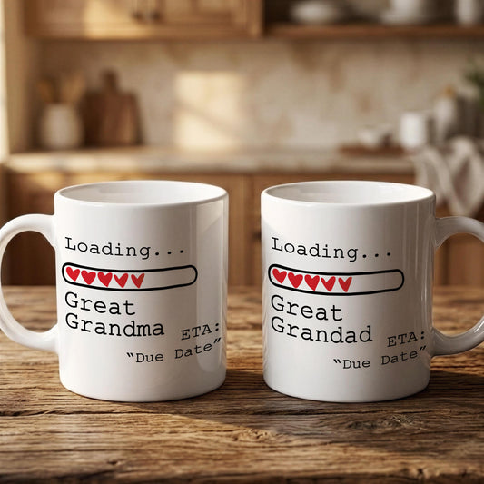 Two white mugs with text and graphics on them, placed on a wooden surface.