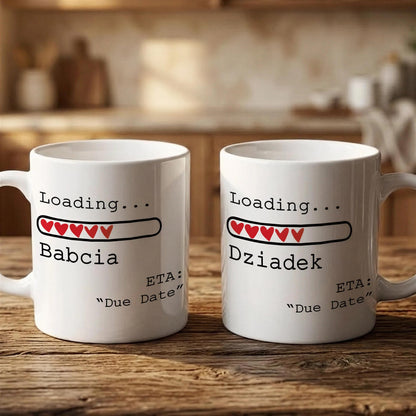 Two white mugs with text and graphics on them, placed on a wooden surface.