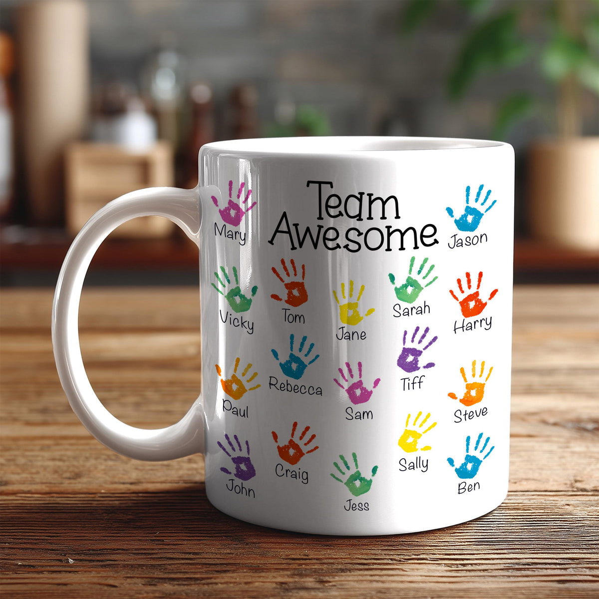 A white ceramic mug with colorful handprints on it, each containing a name.