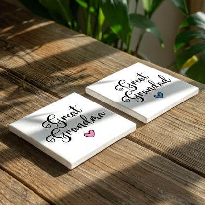 Two white coasters with the text "Great Grandma" printed on them, placed on a wooden surface with some greenery in the background.