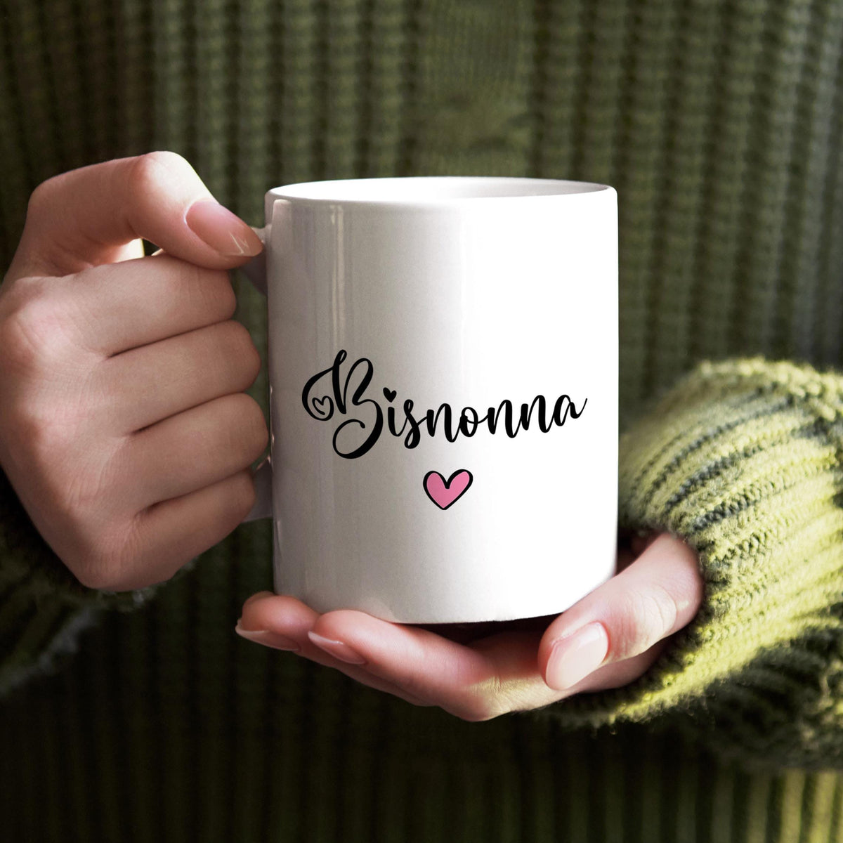 A person's hands holding a white mug with the word "Bisnonna" and a heart symbol printed on it.