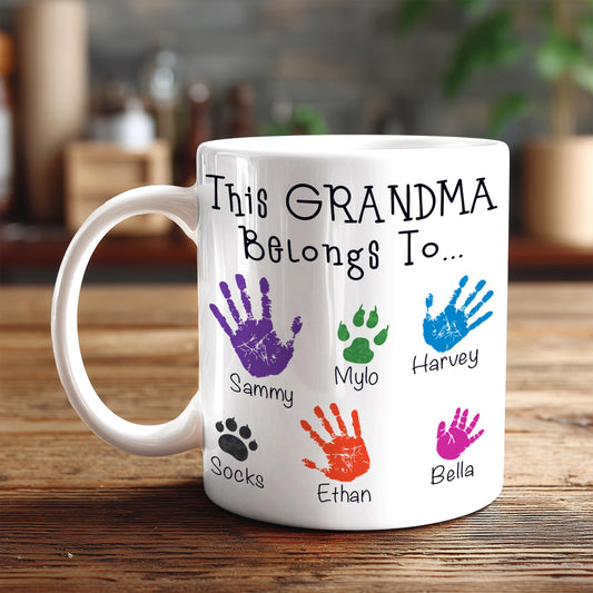 A white mug with a personalized message and handprints of the names of the people it belongs to.