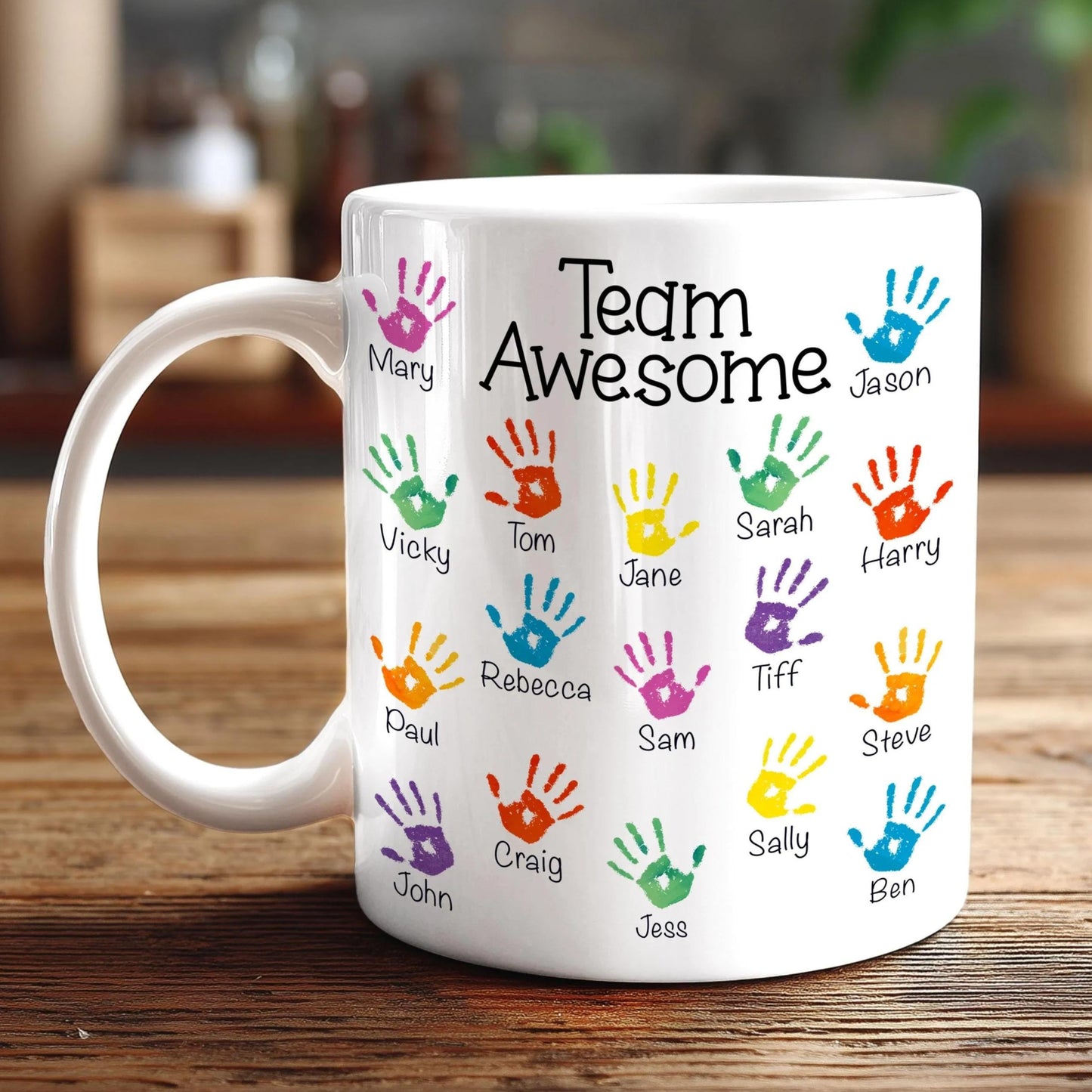 A white mug with colorful handprints on it, each containing a name.