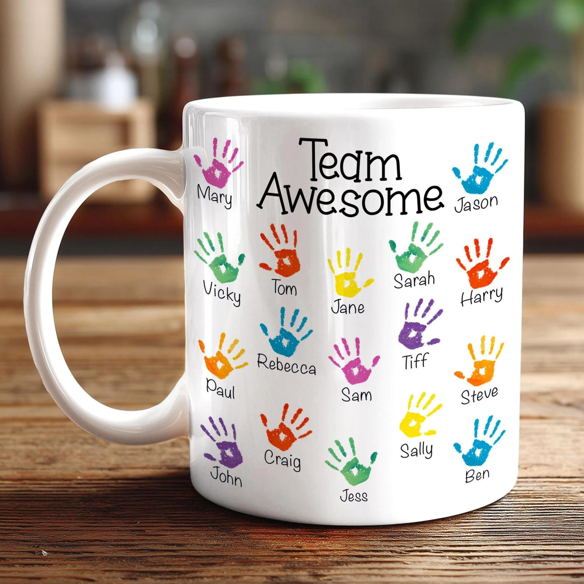 A white mug with colorful handprints on it, each containing a name.