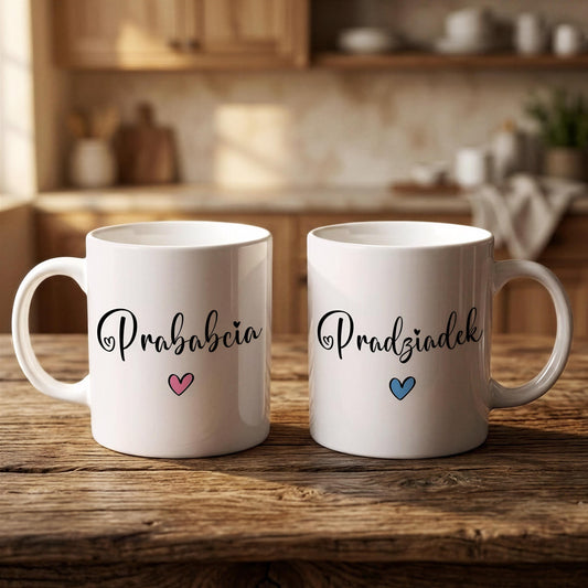 Two white mugs with the Polish phrase "Prabciacia" and a heart symbol printed on them, placed on a wooden surface in a kitchen setting.