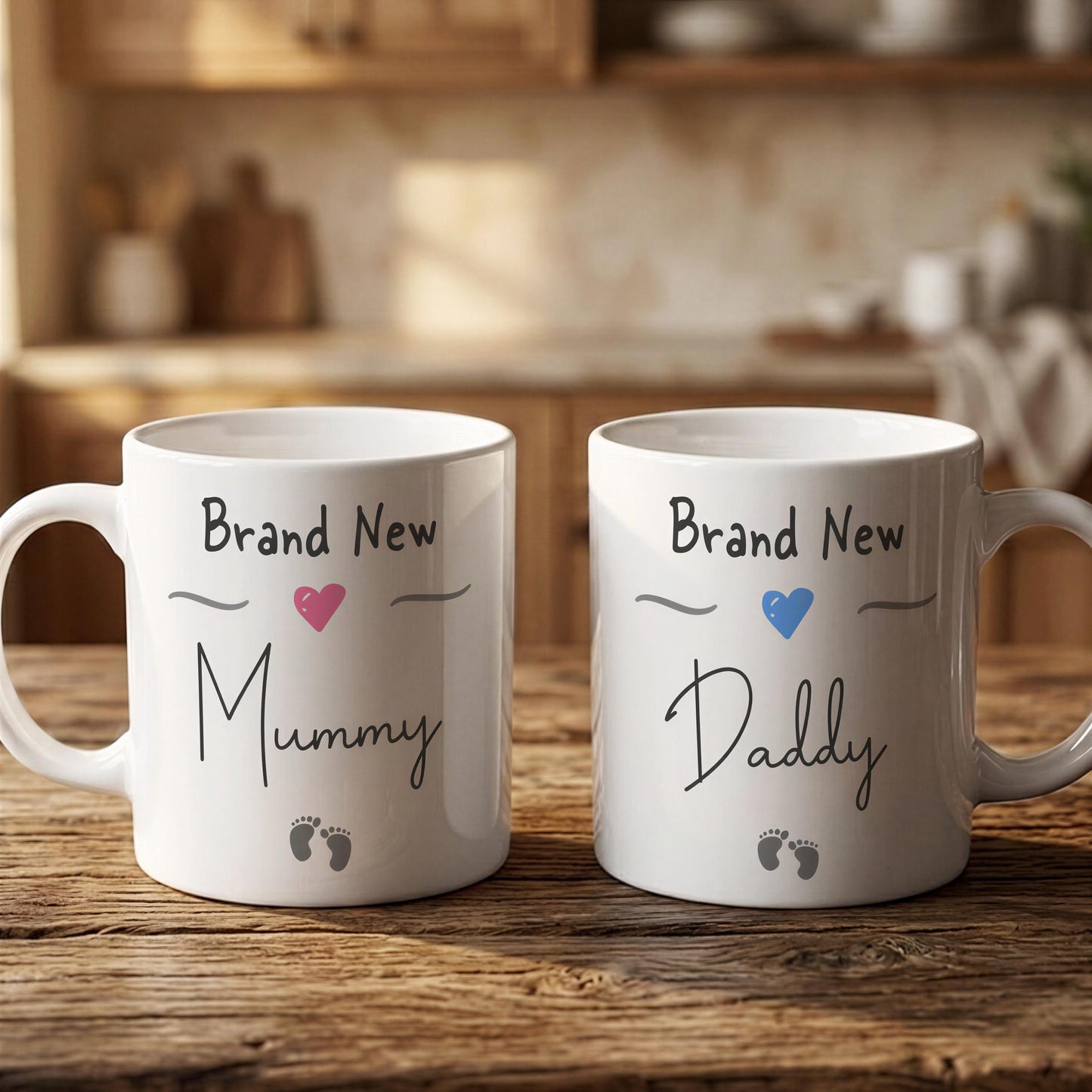 Two white mugs with text that says "Brand New Mummy Daddy" and a heart symbol, placed on a wooden surface.