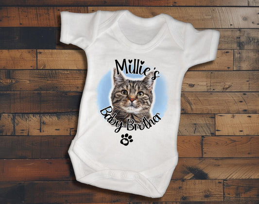 A white baby onesie with a cat image and the text "Milly's Baby Brother" printed on it.
